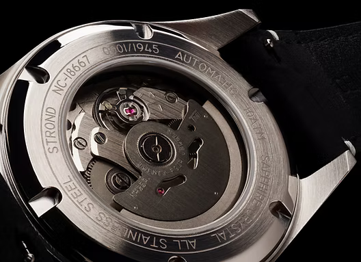 Close-up of a watch's mechanical movement with visible branding on a black background