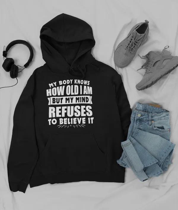 My Body Knows How Old I Am But My Mind Refuses to Believe It Hoodie by Merch
