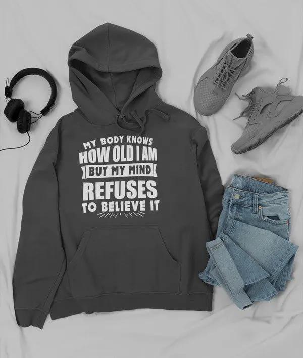 My Body Knows How Old I Am But My Mind Refuses to Believe It Hoodie by Merch