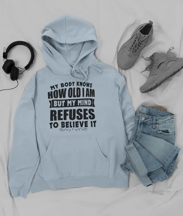 My Body Knows How Old I Am But My Mind Refuses to Believe It Hoodie by Merch